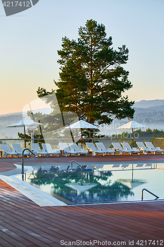 Image of Relaxing chairs beside swimming pool