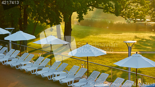 Image of Relaxing chairs beside swimming pool