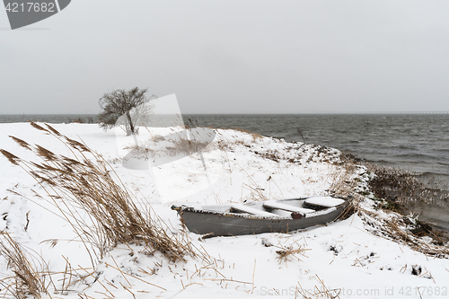 Image of Old rowing boat at a snowy coast