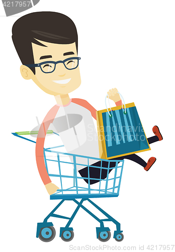Image of Happy man riding by shopping trolley.