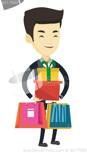 Image of Happy man holding shopping bags and gift boxes.