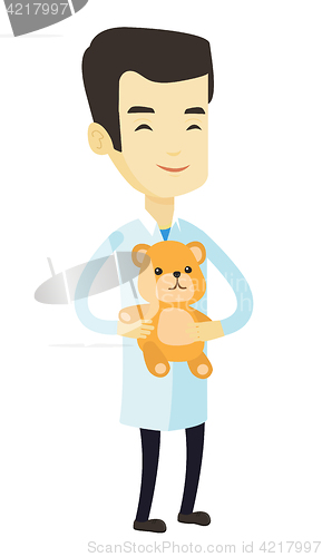 Image of Pediatrician doctor holding teddy bear.