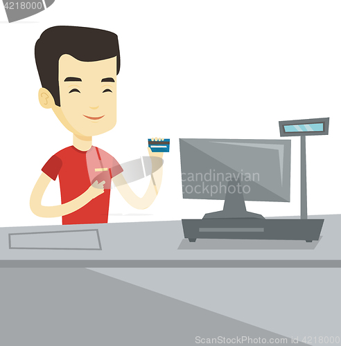 Image of Cashier holding credit card at the checkout.