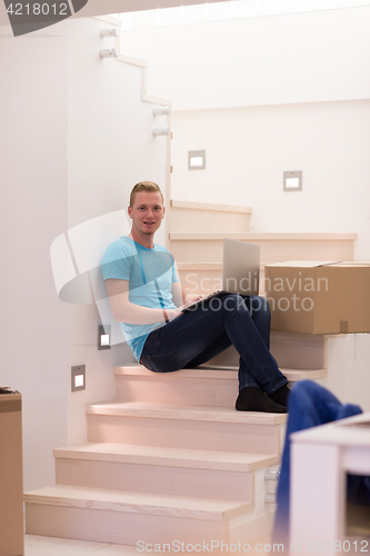 Image of young man sitting in stairway at home