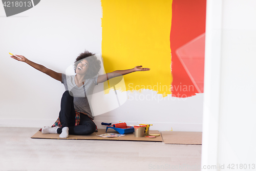 Image of back female painter sitting on floor