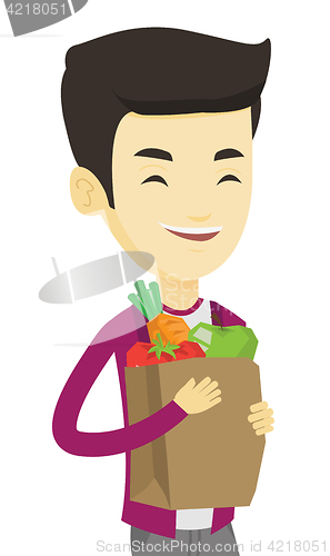 Image of Happy man holding grocery shopping bag.
