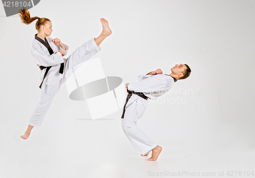 Image of The karate girl and boy with black belts