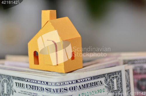 Image of Miniature paper made house stand on  money