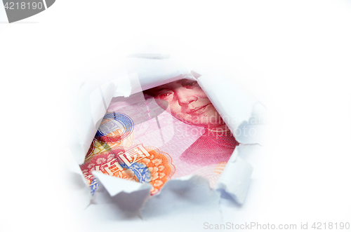 Image of China currency through torn white paper