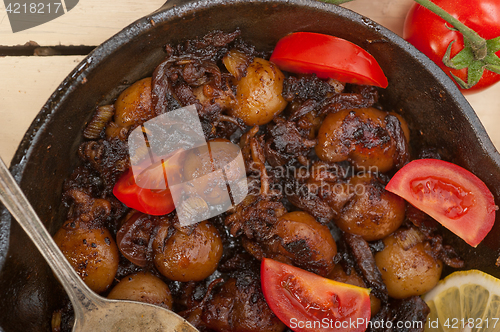 Image of Baby cuttle fish roasted on iron skillet