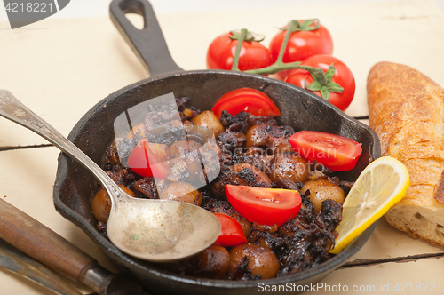 Image of Baby cuttle fish roasted on iron skillet