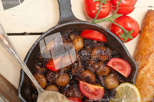 Image of Baby cuttle fish roasted on iron skillet