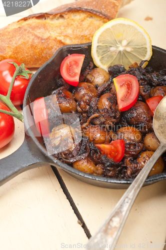 Image of Baby cuttle fish roasted on iron skillet