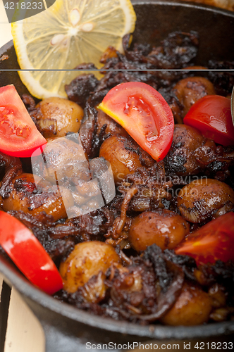 Image of Baby cuttle fish roasted on iron skillet