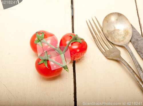 Image of ripe cherry tomatoes over white wood