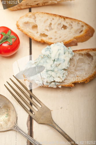 Image of fresh blue cheese spread ove french baguette