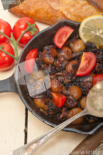 Image of Baby cuttle fish roasted on iron skillet