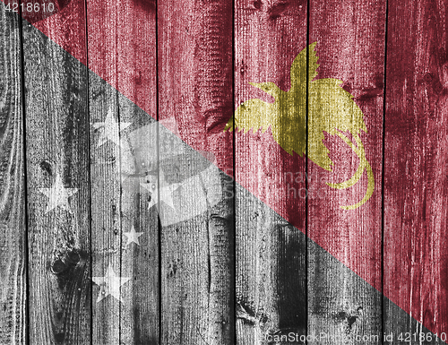 Image of Flag of Papua New Guinea on weathered wood