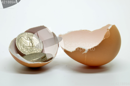 Image of Cracked egg shell and coins