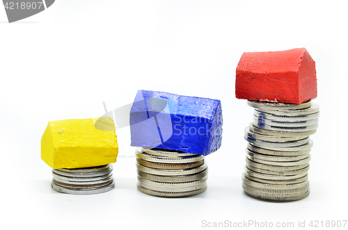 Image of Coins stacked up in piles with color house