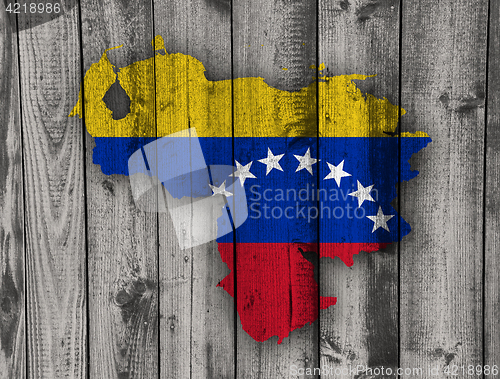 Image of Map and flag of Venezuela on weathered wood