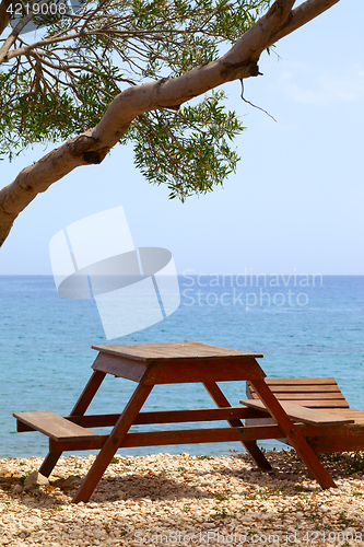 Image of Wooden table and deck chair on summer resort at sun day