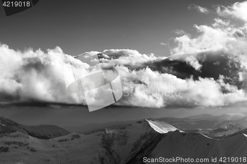 Image of Black and white winter mountains in evening and sunlight clouds