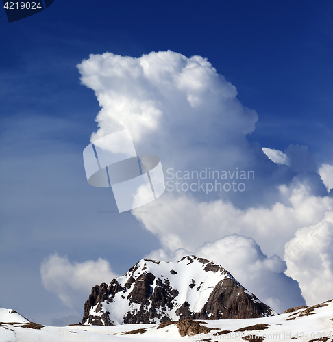 Image of Rocks in snow and blue sky with clouds