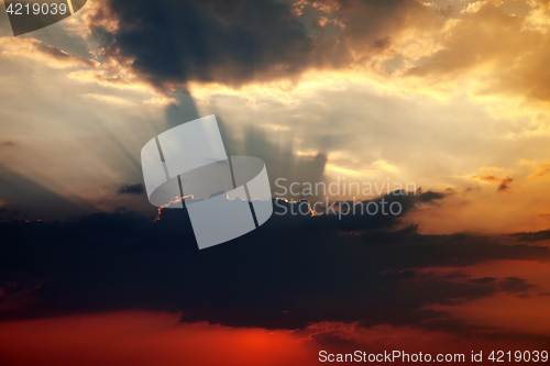 Image of Sunset sky with dark clouds and sun rays