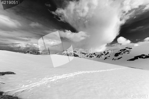 Image of Black and white view on snowy mountains and sky with clouds