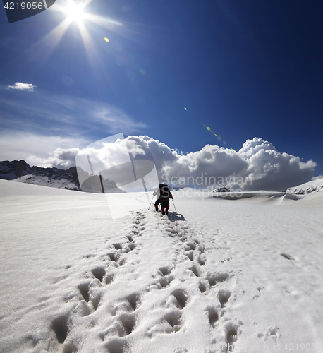 Image of Two hikers on snow plateau.