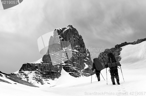 Image of Two hikers in snowy mountains before storm