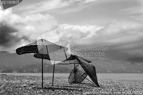 Image of Black and white old sunshade on deserted beach