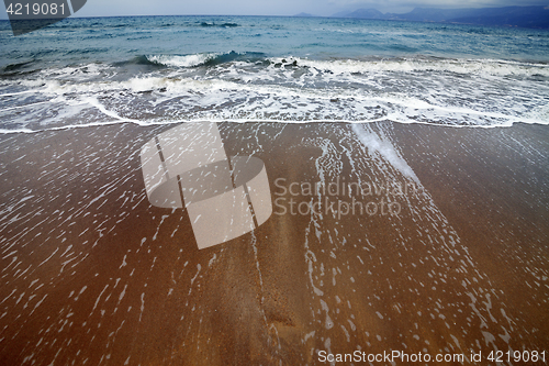 Image of Sea beach with waves in gray day