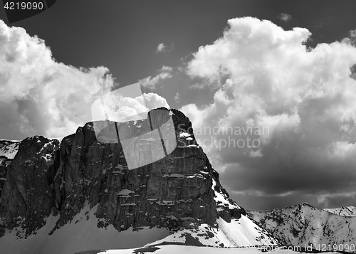 Image of Black and white view on snowy rocks and sky with clouds in nice 