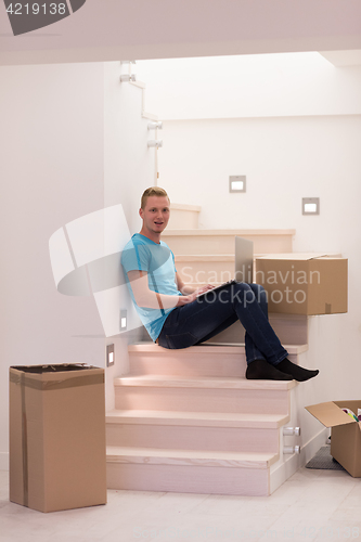 Image of young man sitting in stairway at home