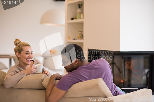 Image of Young multiethnic couple  in front of fireplace