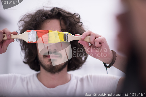 Image of man with funny hair over color background with brush