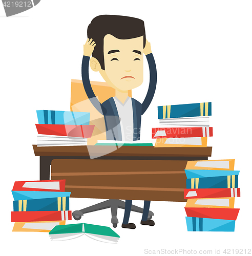 Image of Student sitting at the table with piles of books.