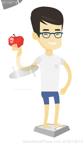 Image of Man standing on scale and holding apple in hand.