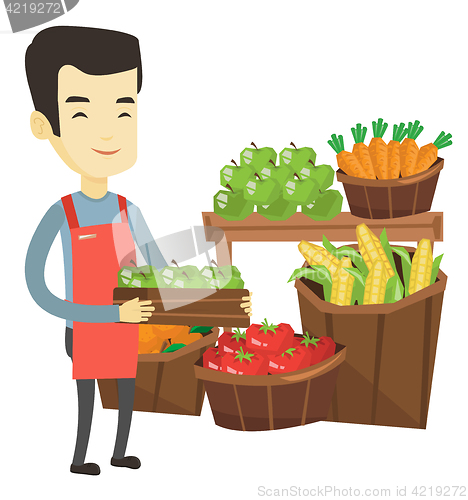 Image of Supermarket worker with box full of apples.