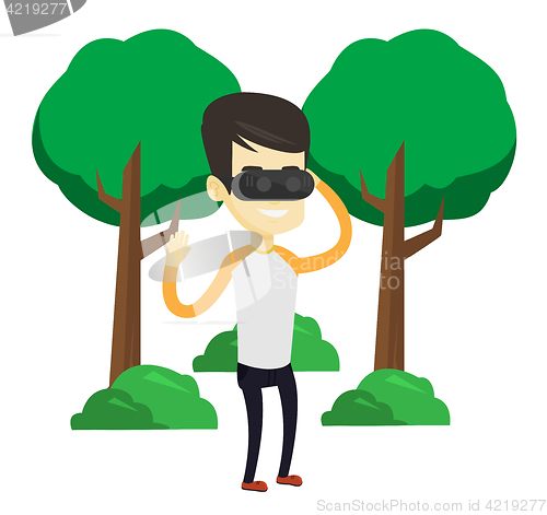 Image of Man wearing virtual reality headset in the park.