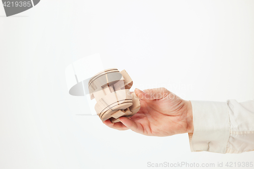 Image of Man\'s hands holding wooden puzzle.