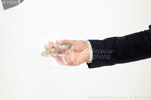 Image of Man\'s hands holding wooden puzzle.