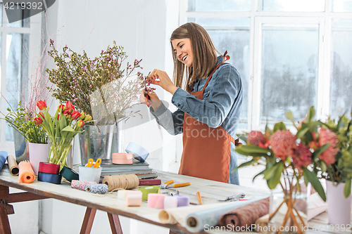 Image of Florist at work: the young girl making fashion modern bouquet of different flowers