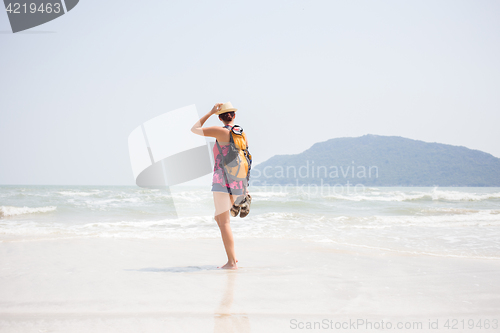 Image of Brunette with sandals in hands