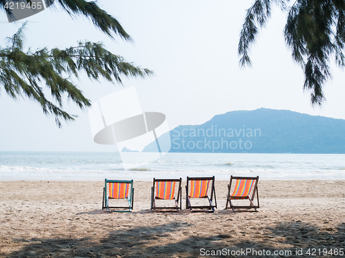 Image of Four chaise lounges on beach