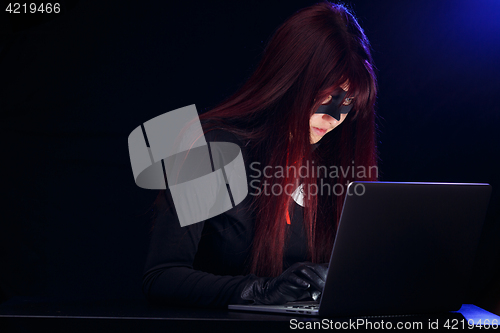 Image of Young brunette thief with laptop