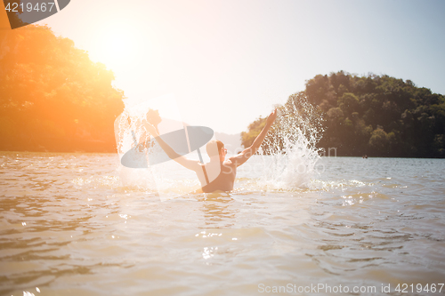 Image of Man arms raised in sea