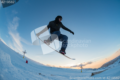 Image of Snowboarder jumping against blue sky